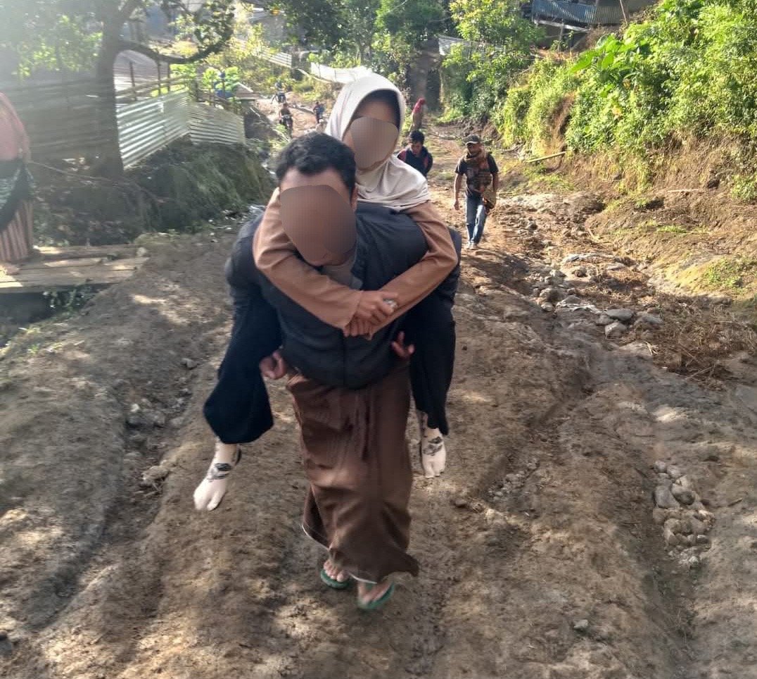 Jalan Rusak, Bocah Terpaksa Dibopong Ayah untuk Berobat
